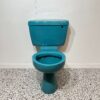 blue close coupled toilet with white back drop and bathroom tiles