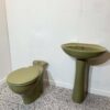 Avocado toilet and sink set on white backdrop with bathroom tiles and avocado toilet seat