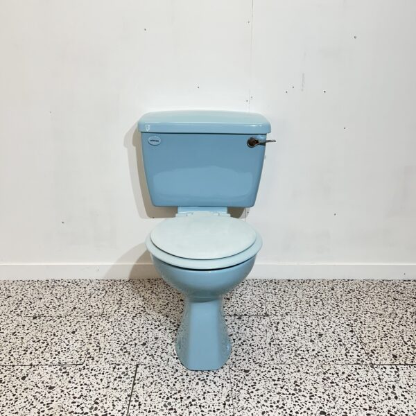 retro close coupled sky blue toilet made by shires with white backdrop and bathroom tiles